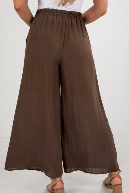 Brown wide-leg pants worn by a person on a white background