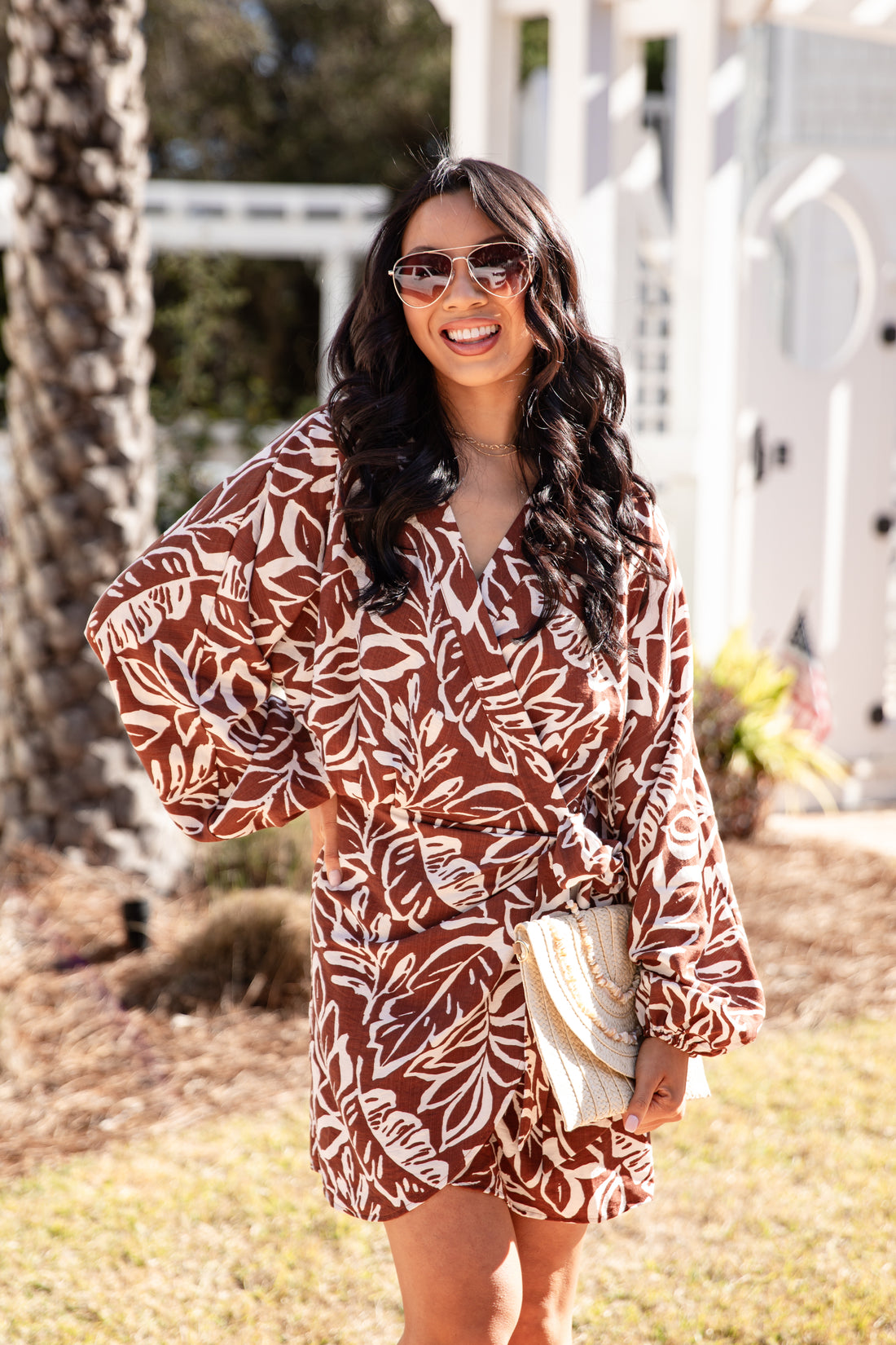 Woman wearing a brown and white patterned dress outdoors.