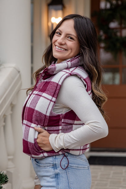 Woman wearing a plaid vest and scarf outdoors