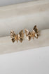 Gold butterfly earrings on a marble surface