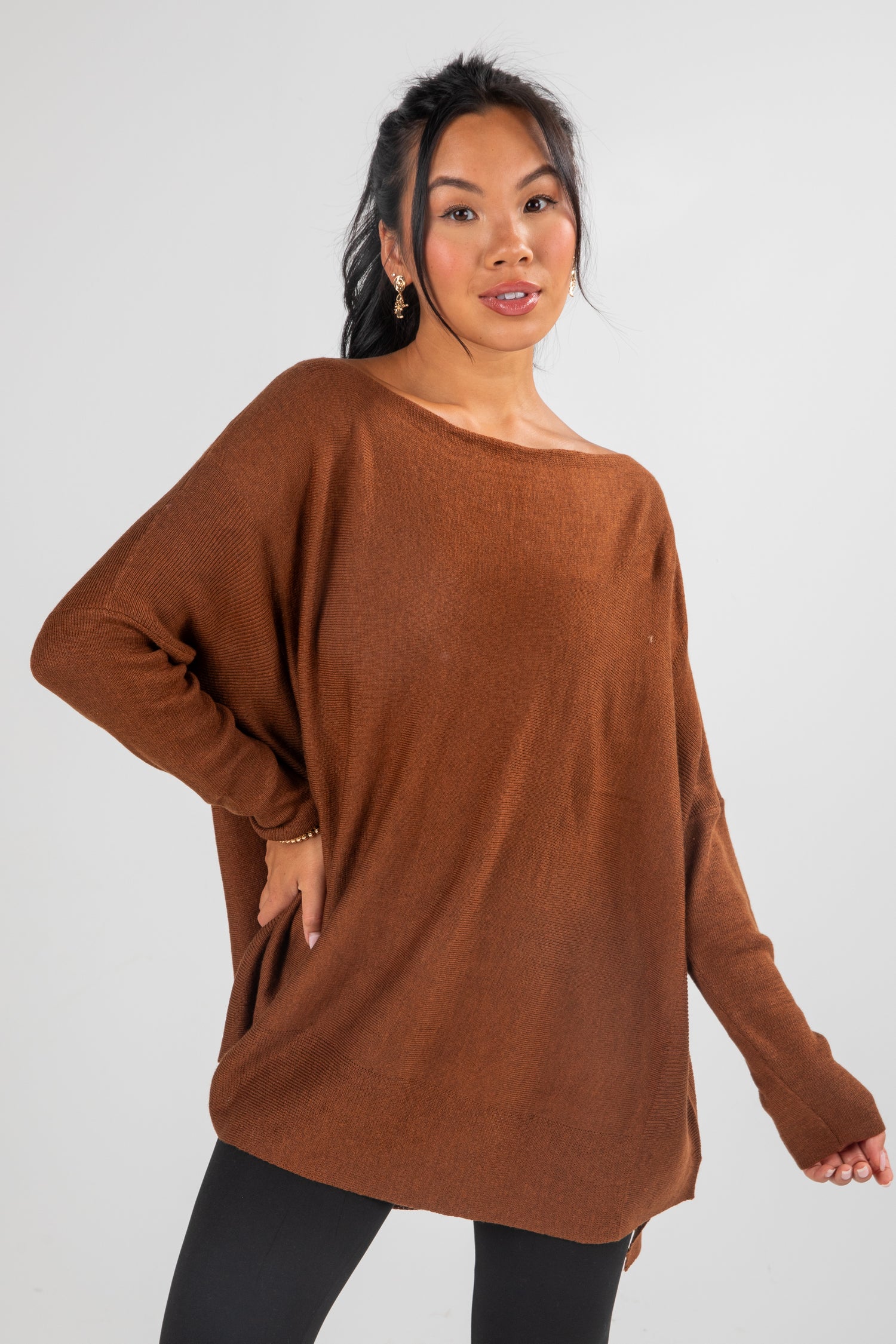 Woman wearing a brown sweater against a white background