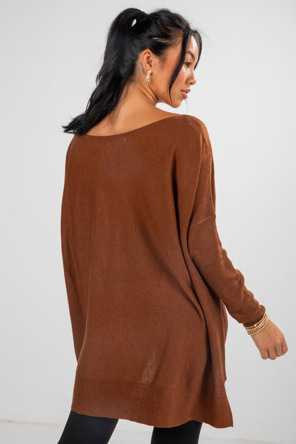 Woman wearing a brown sweater against a white background