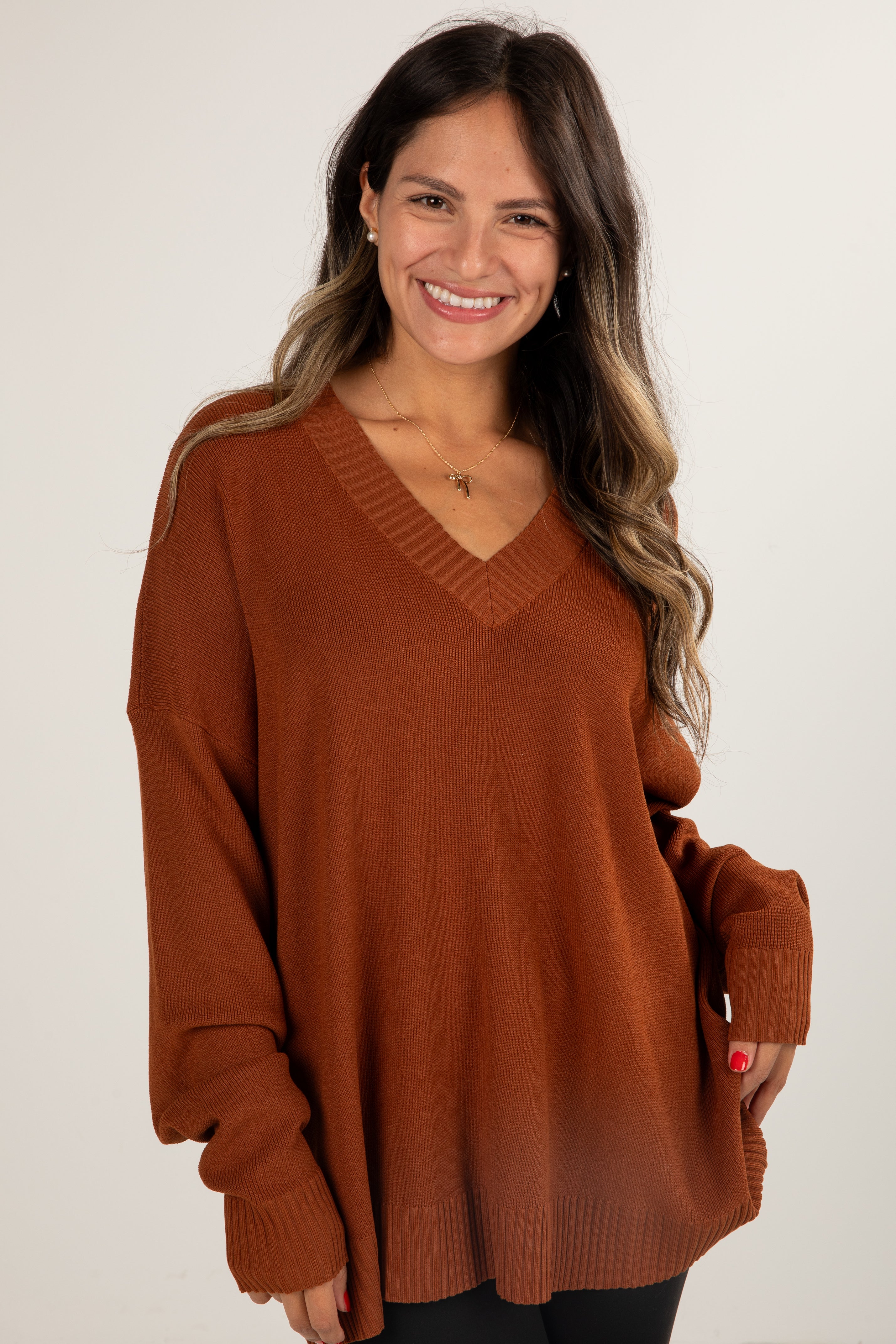 Woman wearing a brown sweater against a white background