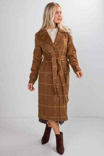 Woman wearing a brown plaid coat on a white background