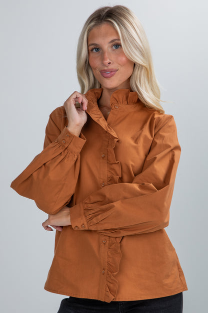 Woman wearing a brown jacket against a plain background