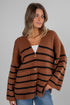 Woman wearing a brown and black striped cardigan on a gray background