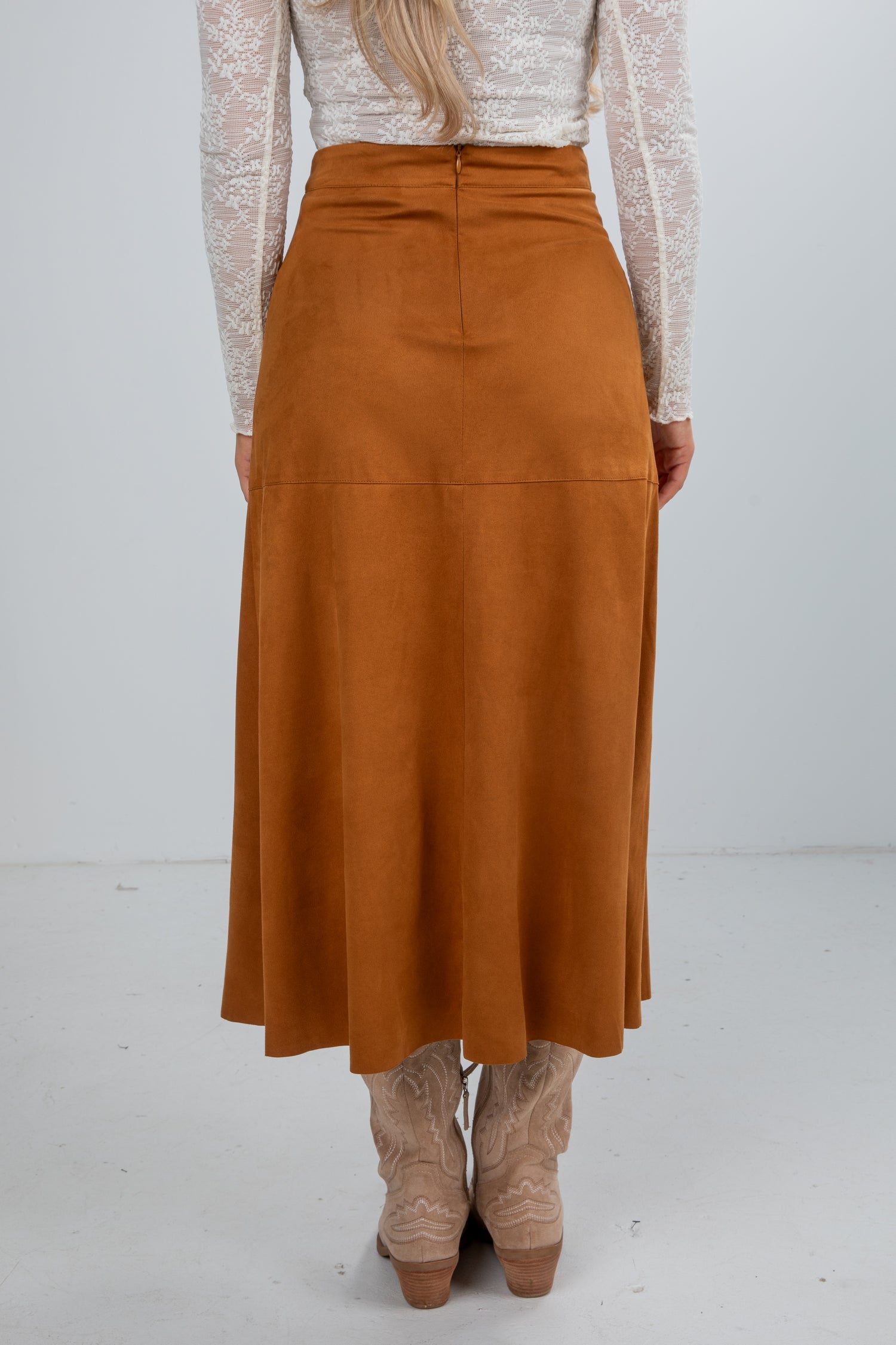 Person wearing a brown skirt with a white background