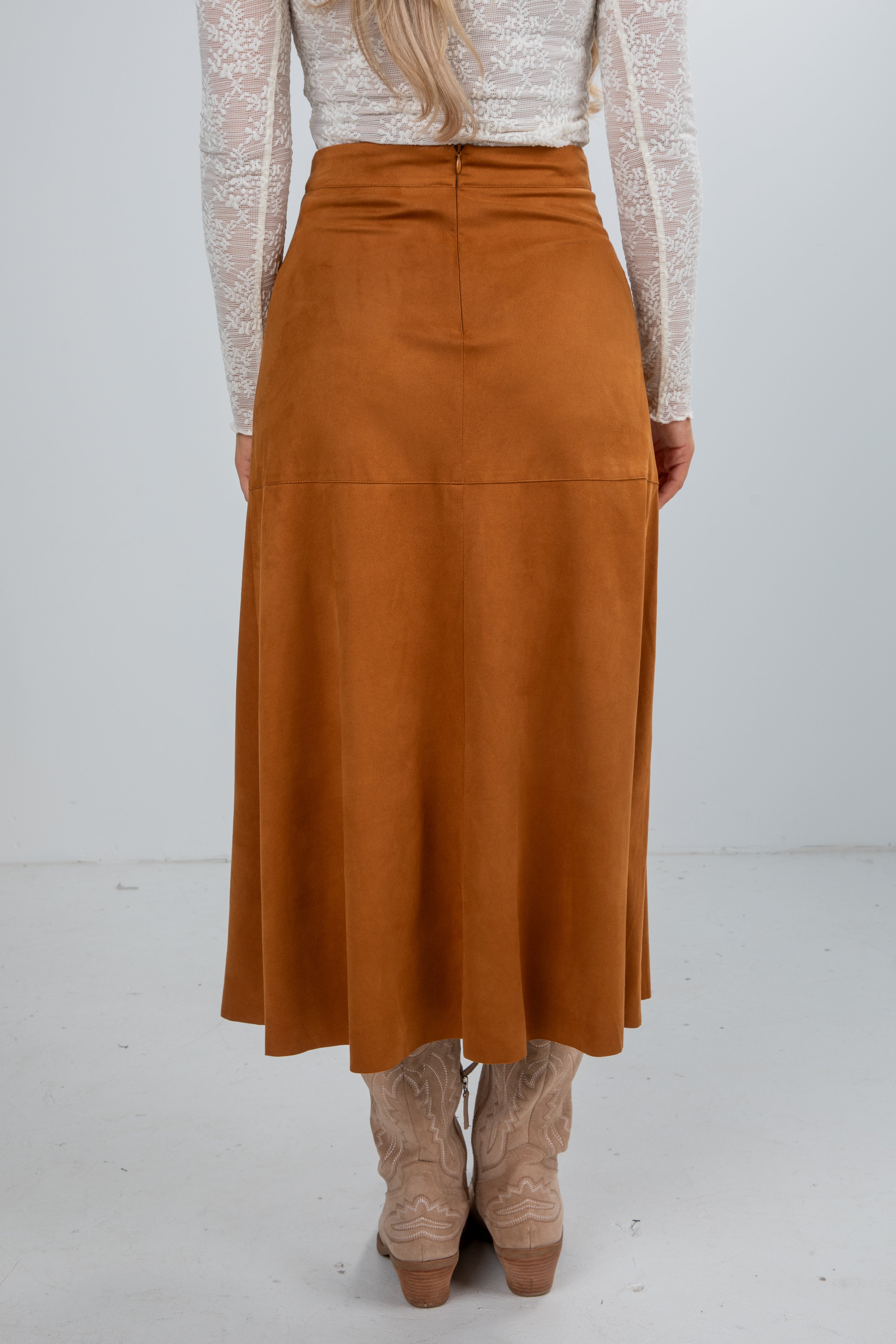 Person wearing a brown skirt with a white background