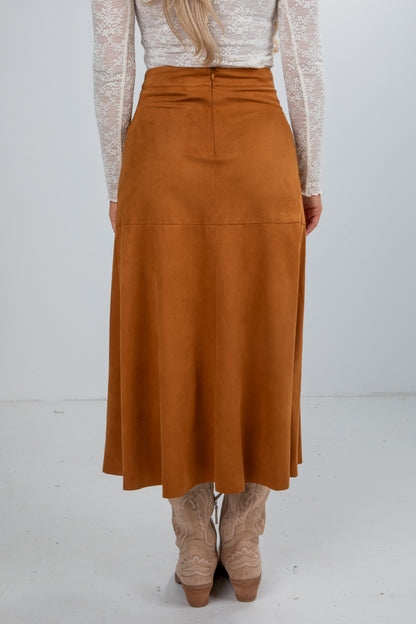 Person wearing a brown skirt with a white background