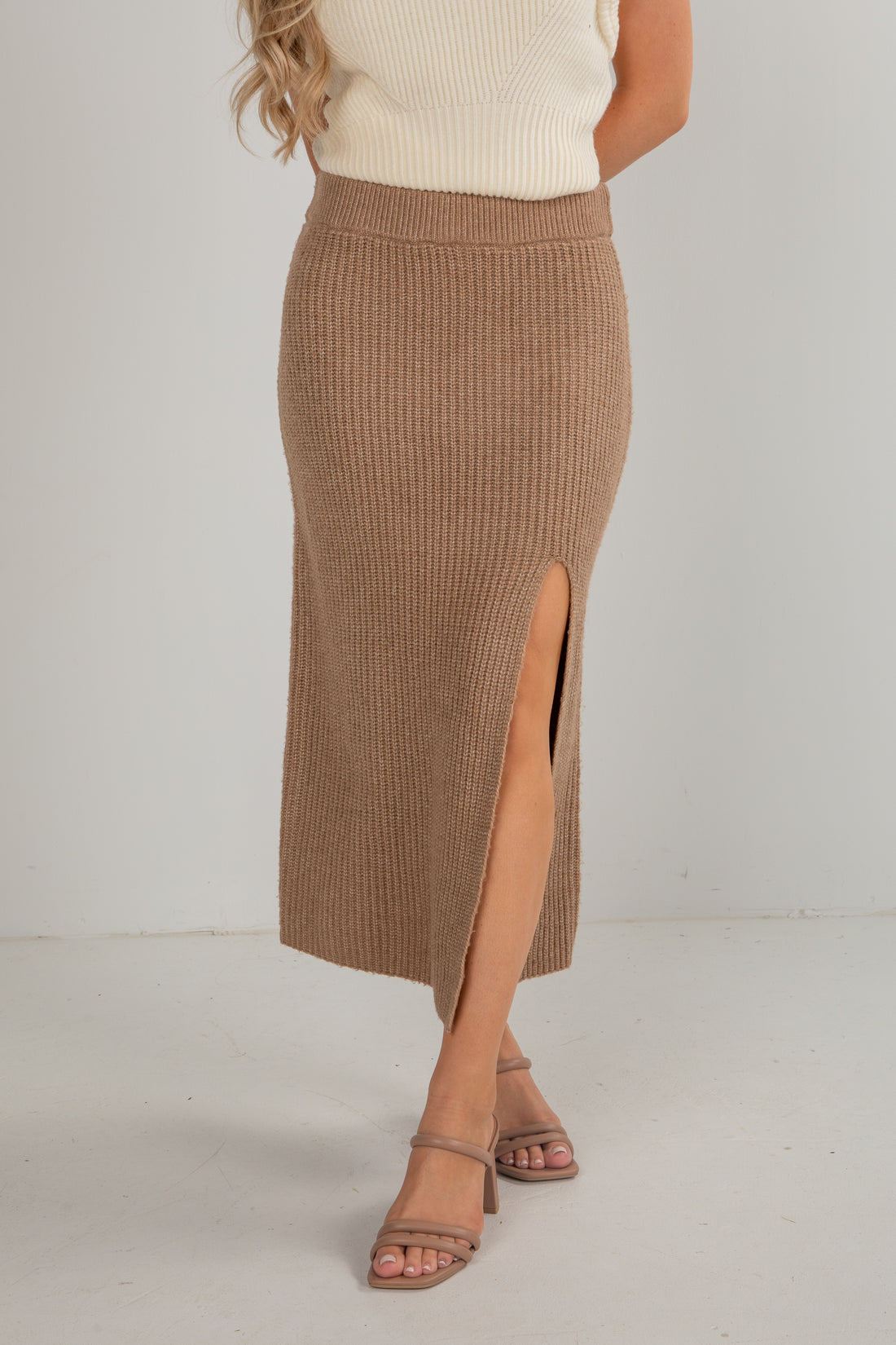 Brown ribbed skirt with a slit worn by a person on a white background
