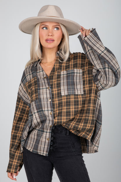 Woman wearing a plaid shirt and hat against a plain background