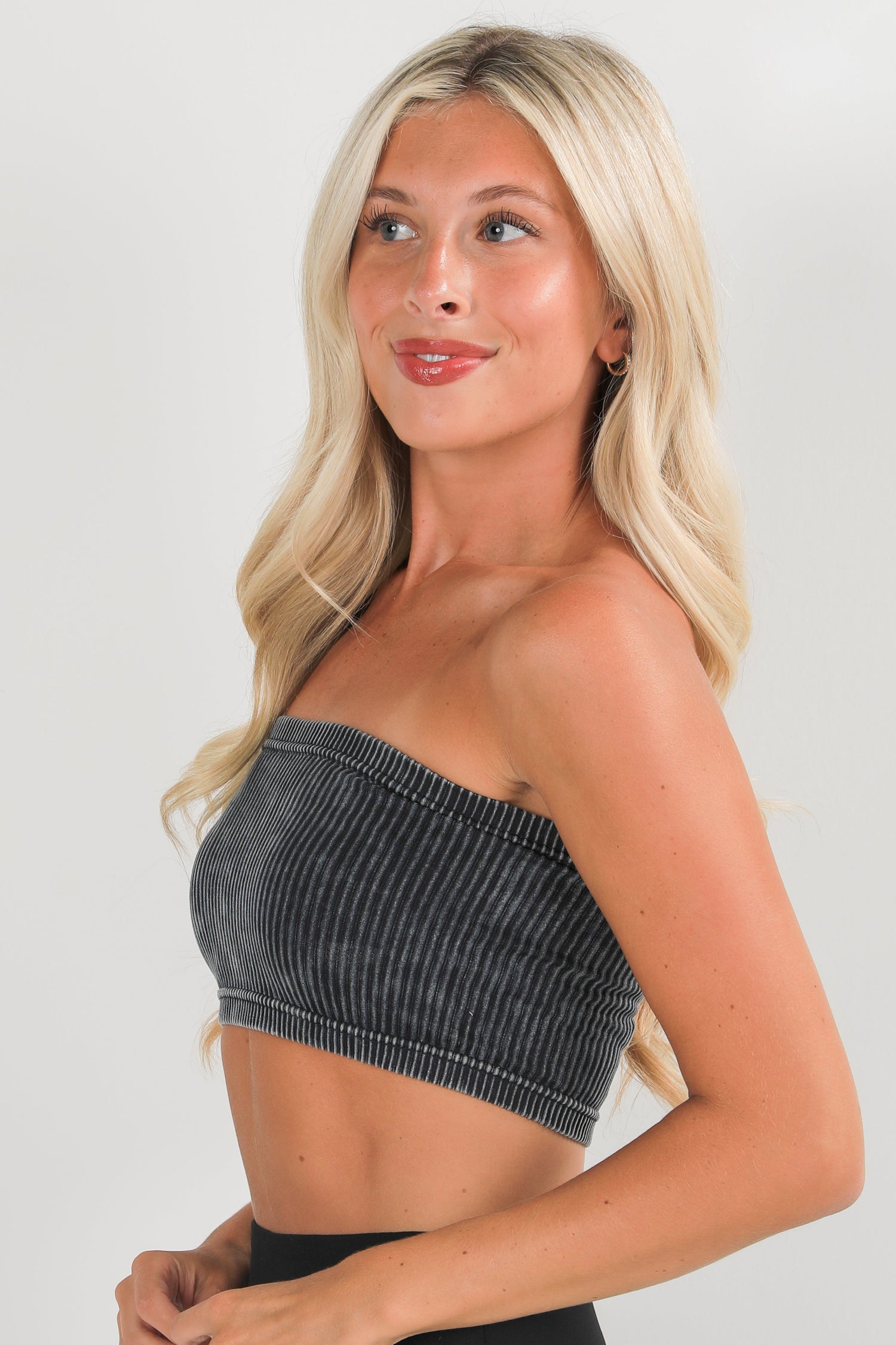 Woman wearing a strapless top with a plain background