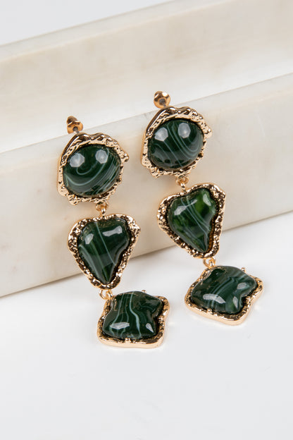 Green gemstone earrings with gold accents on a white background