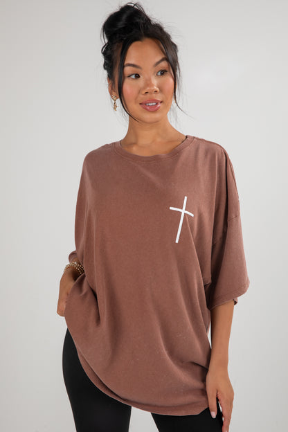 Woman wearing a brown oversized shirt with a white &