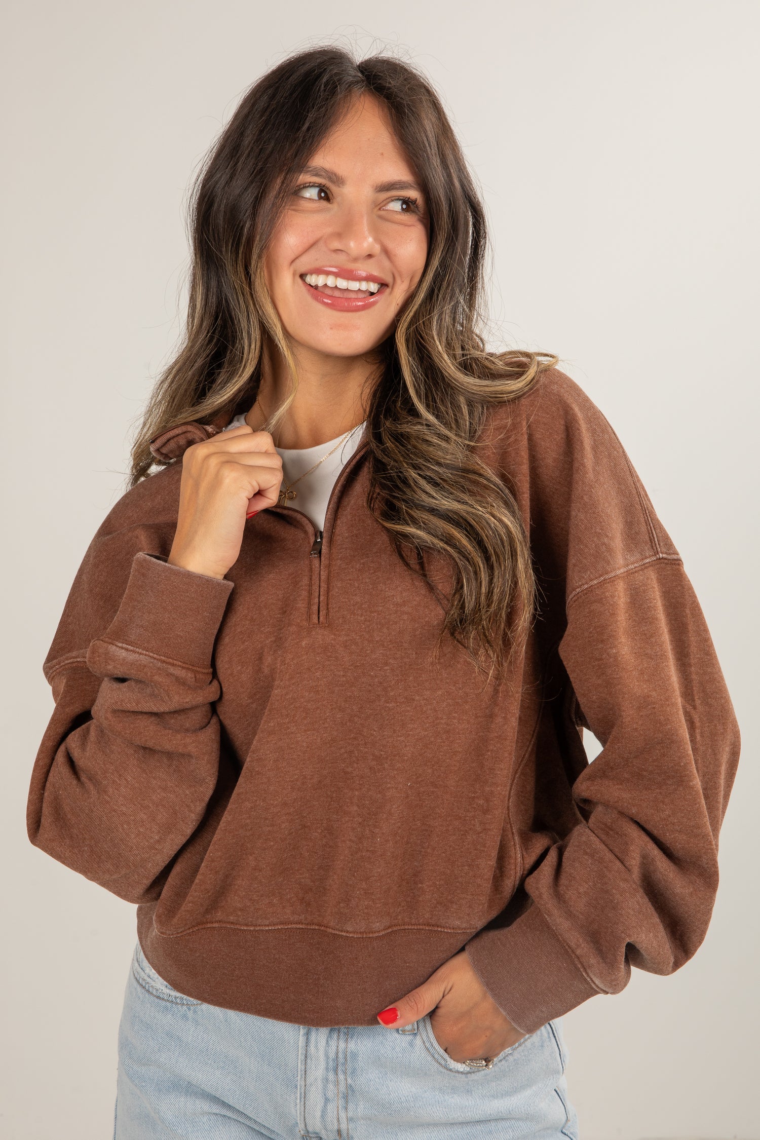 Woman wearing a brown pullover with a white background