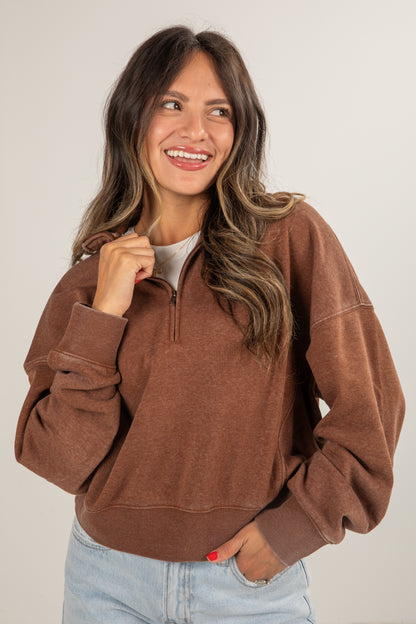 Woman wearing a brown pullover with a white background