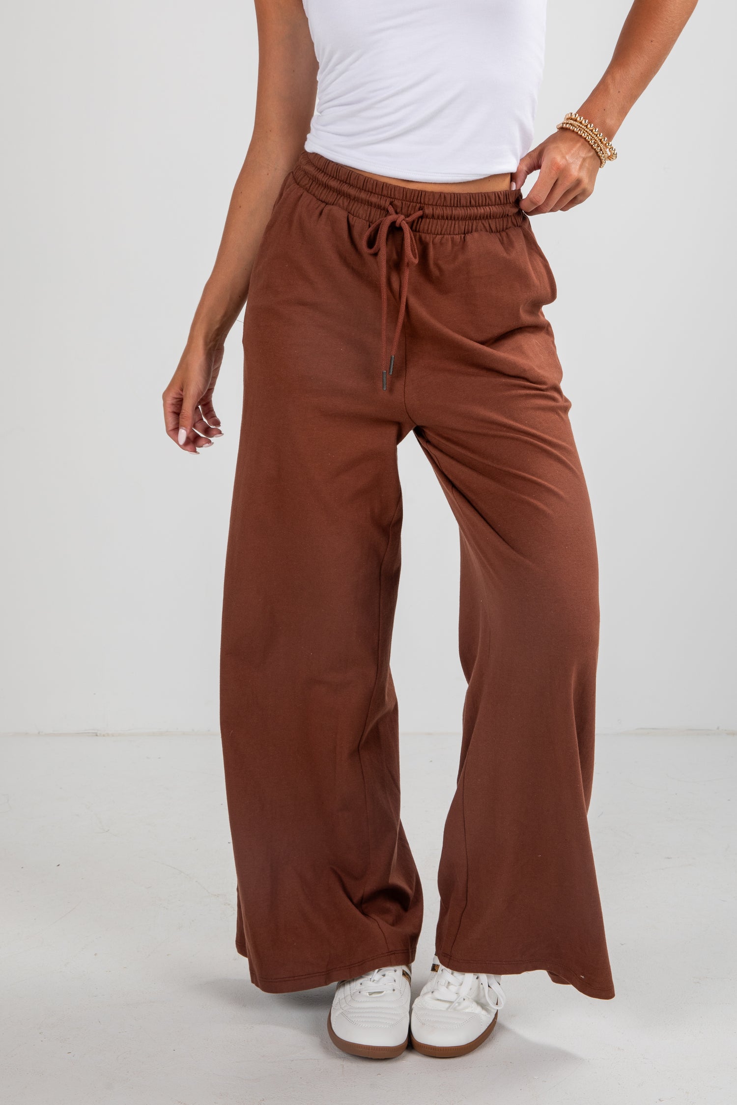 Brown wide-leg pants worn by a person on a white background