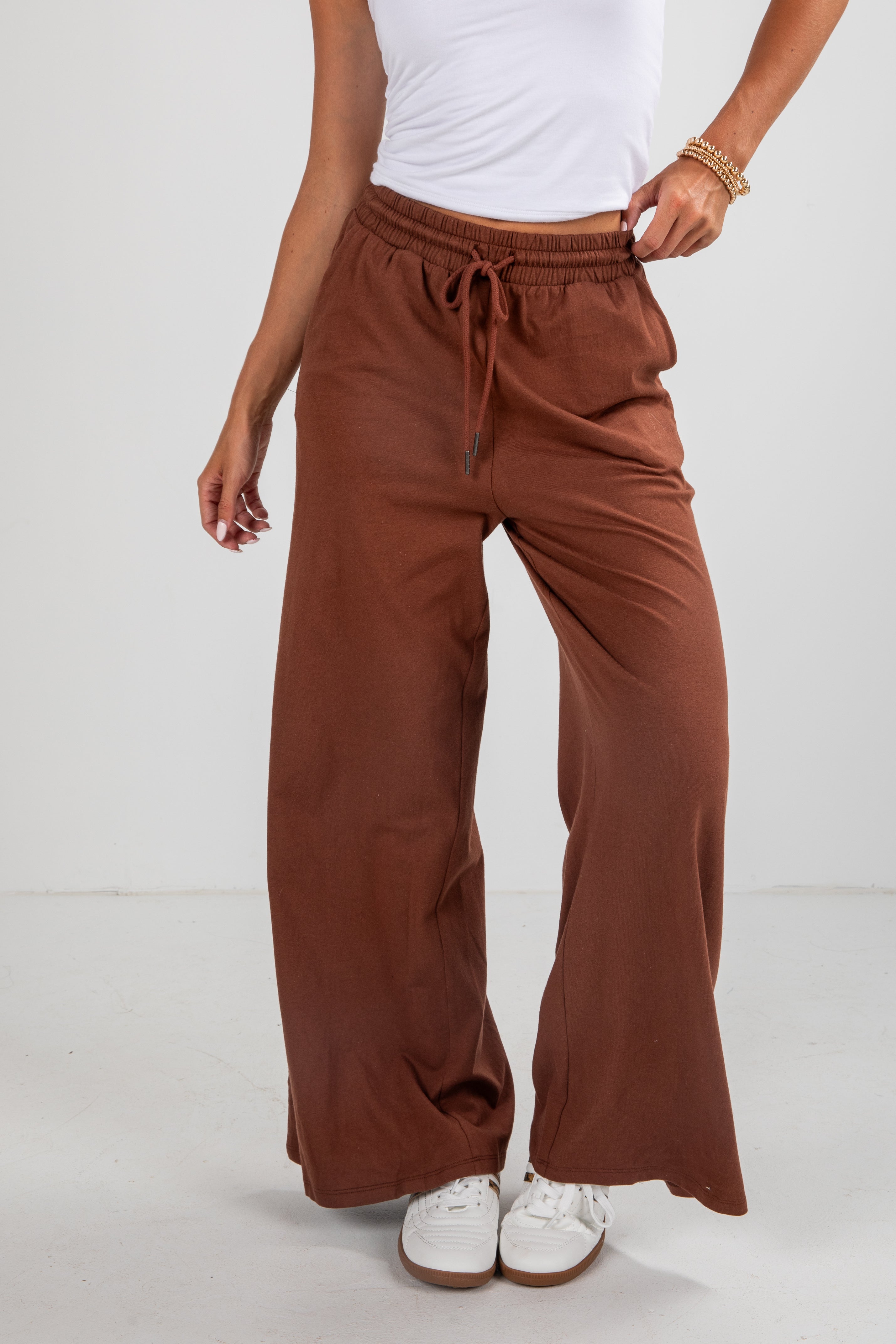 Brown wide-leg pants worn by a person on a white background