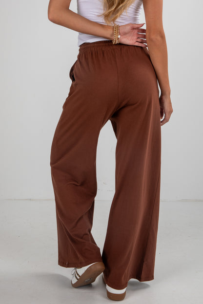 Brown wide-leg pants worn by a person on a white background