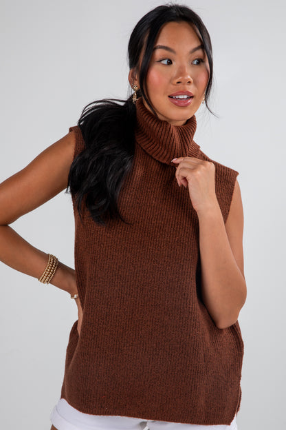 Woman wearing a brown sleeveless turtleneck sweater against a white background