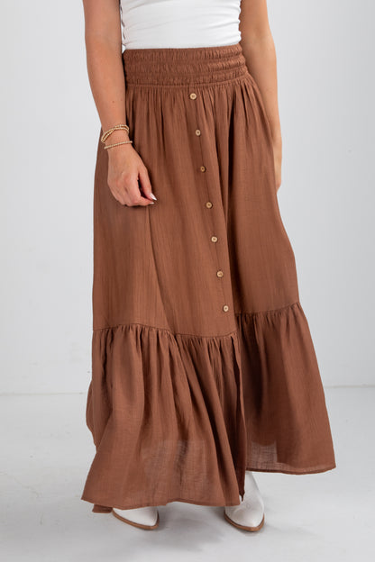 Brown tiered skirt worn by a person on a white background