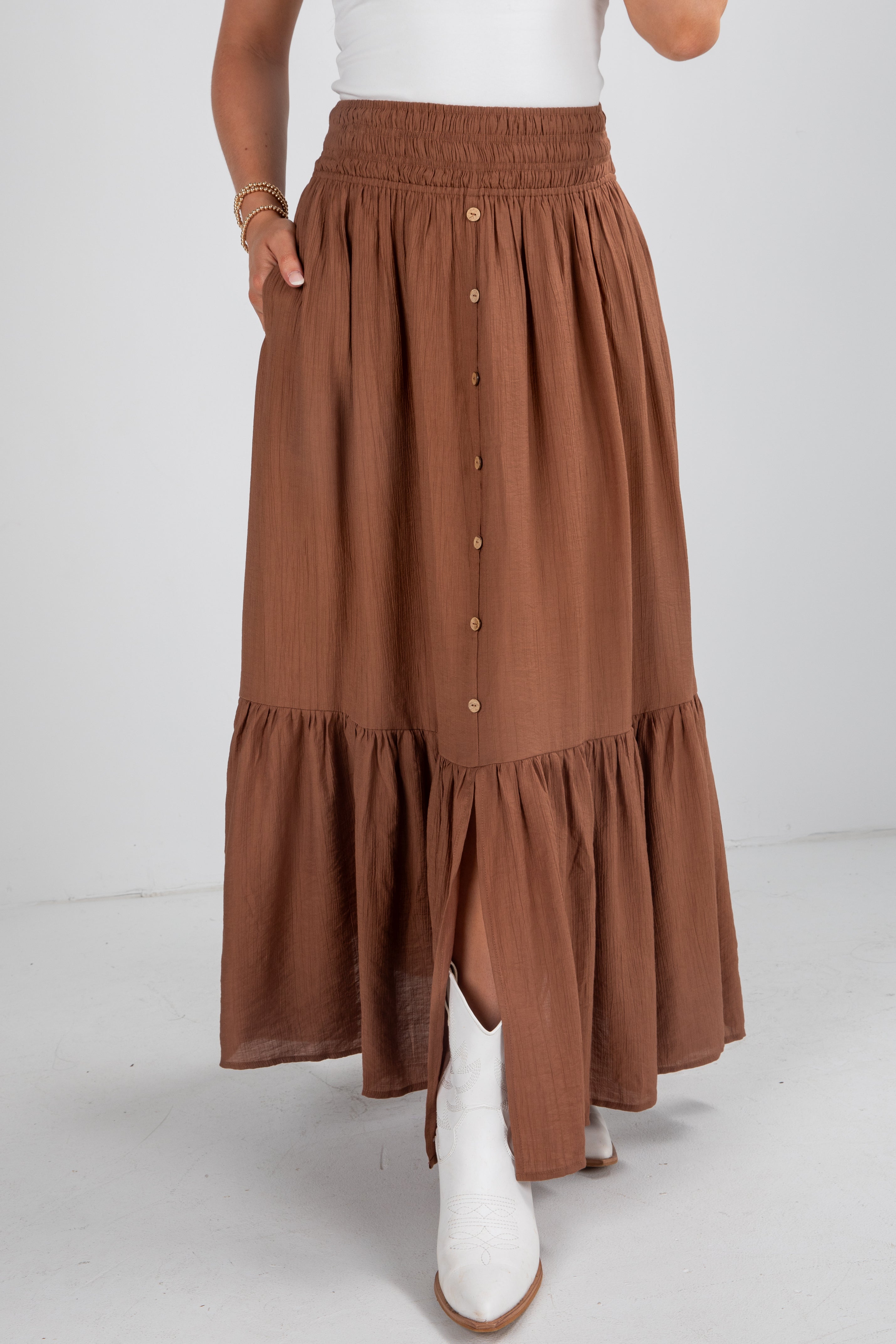 Brown tiered skirt worn by a person on a white background