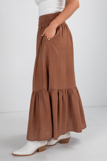 Brown tiered skirt worn by a person on a white background