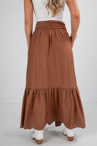 Person wearing a brown tiered skirt on a white background