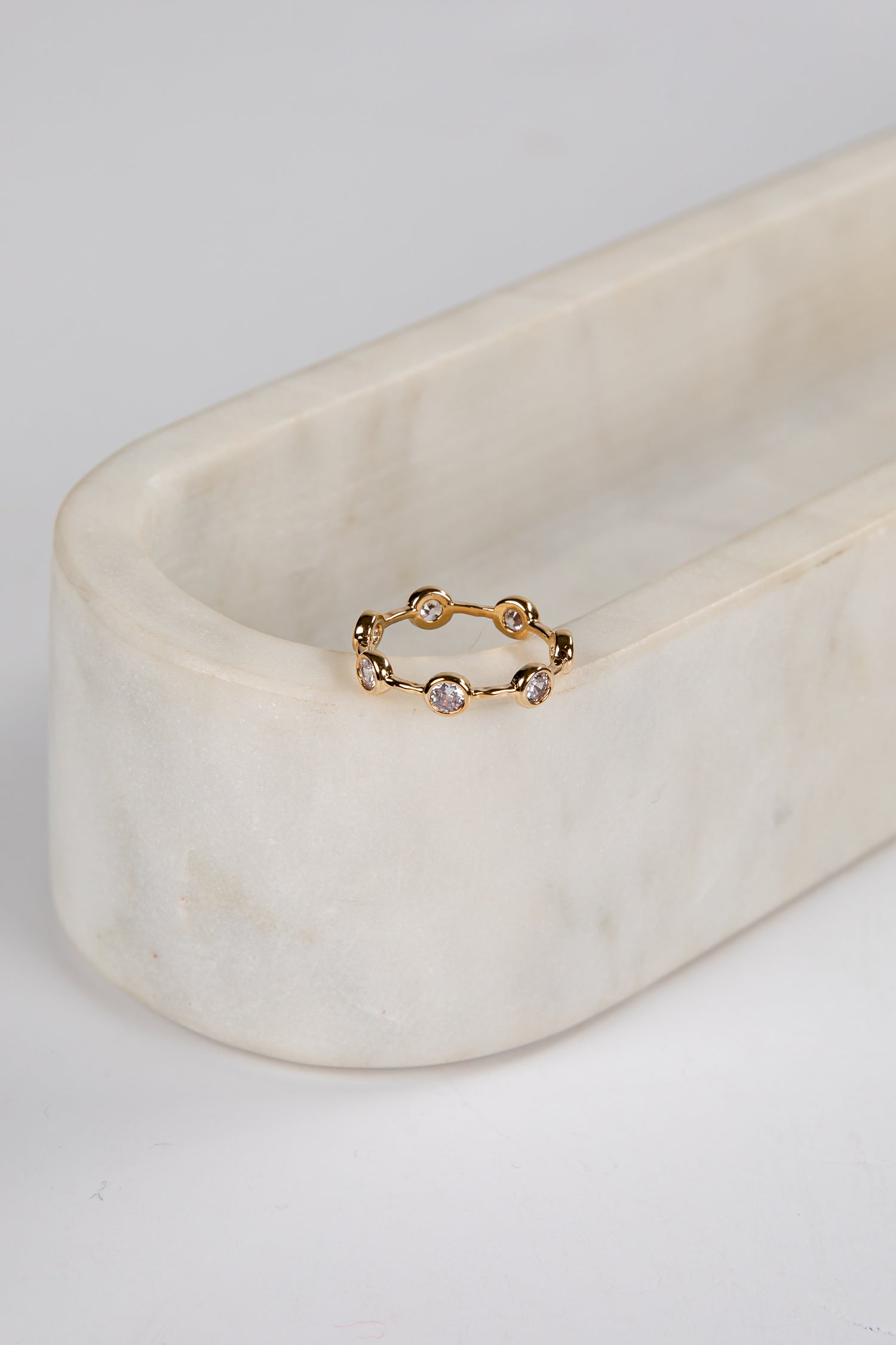 Gold ring with small stones on a marble surface