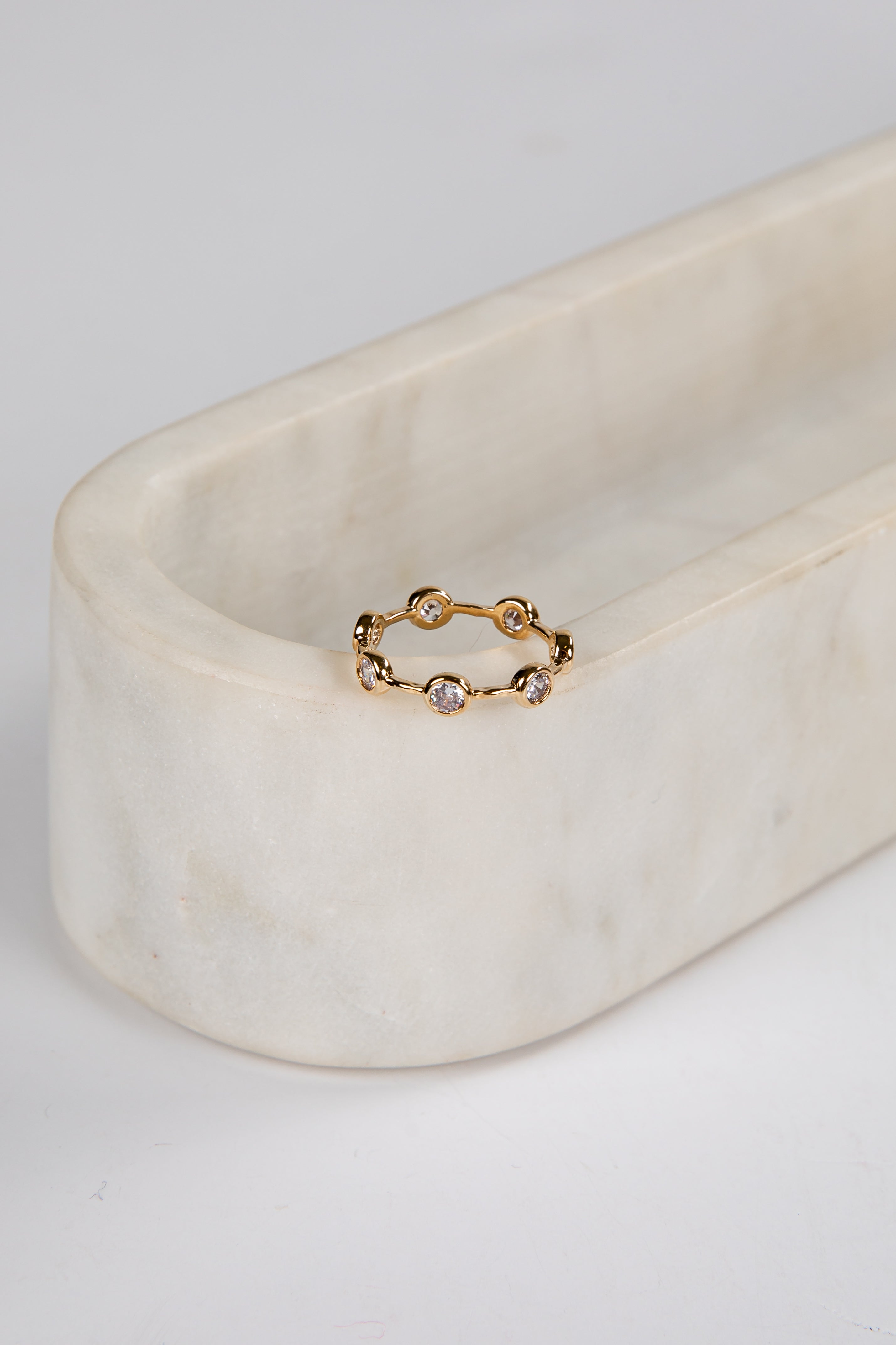 Gold ring with small stones on a marble surface