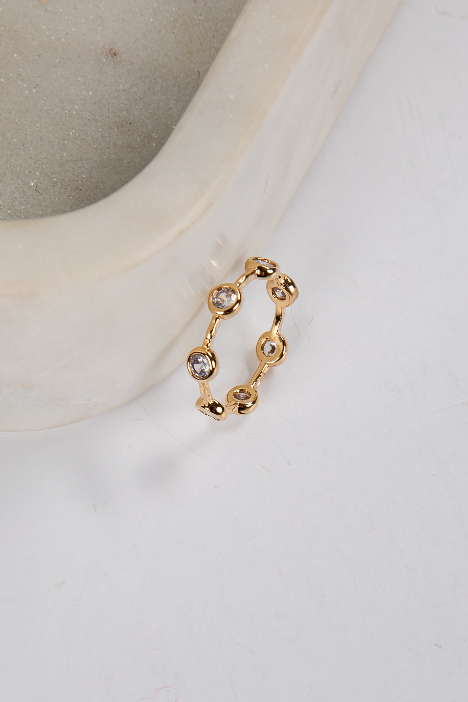 Gold ring with small stones on a white surface