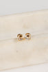 Gold stud earrings on a marble surface