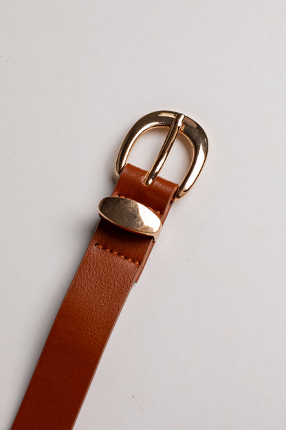 A close-up of a brown leather belt strap with a polished gold-tone metal buckle, resting on a light gray background.