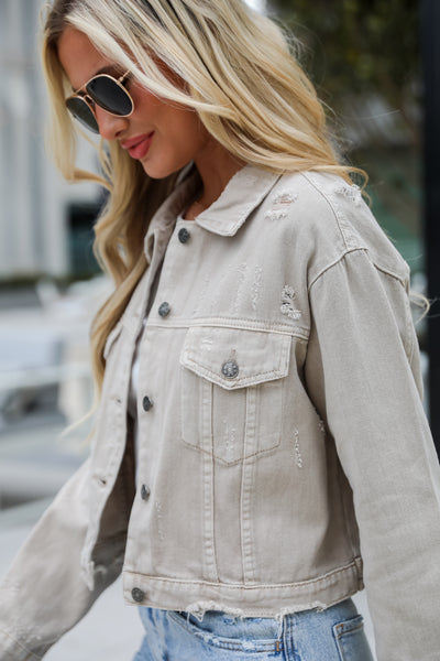 denim jacket for spring. Definite Icon Taupe Distressed Cropped Denim Jacket is lighweight, mid-crop fit, and the perfect spring layer. Taupe jacket. spring jacket.