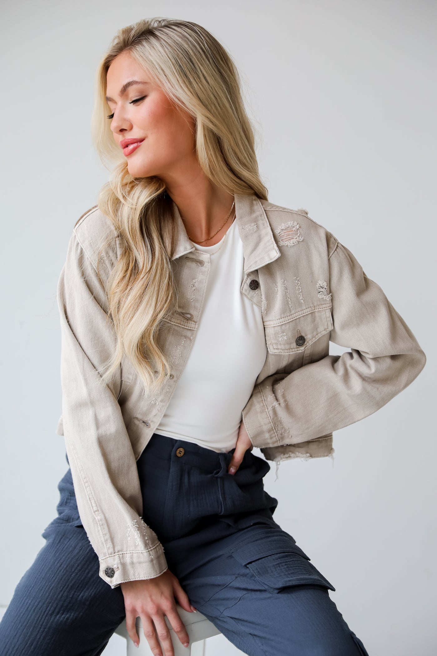 Definite Icon Taupe Distressed Cropped Denim Jacket is lighweight, mid-crop fit, and the perfect spring layer. Taupe jacket. spring jacket.cropped denim jacket