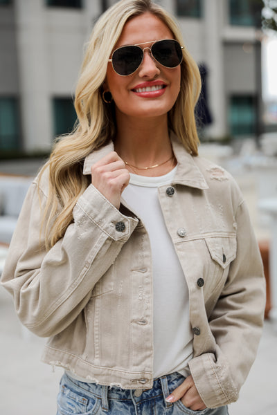 Definite Icon Taupe Distressed Cropped Denim Jacket is lighweight, mid-crop fit, and the perfect spring layer. Taupe jacket. spring jacket.