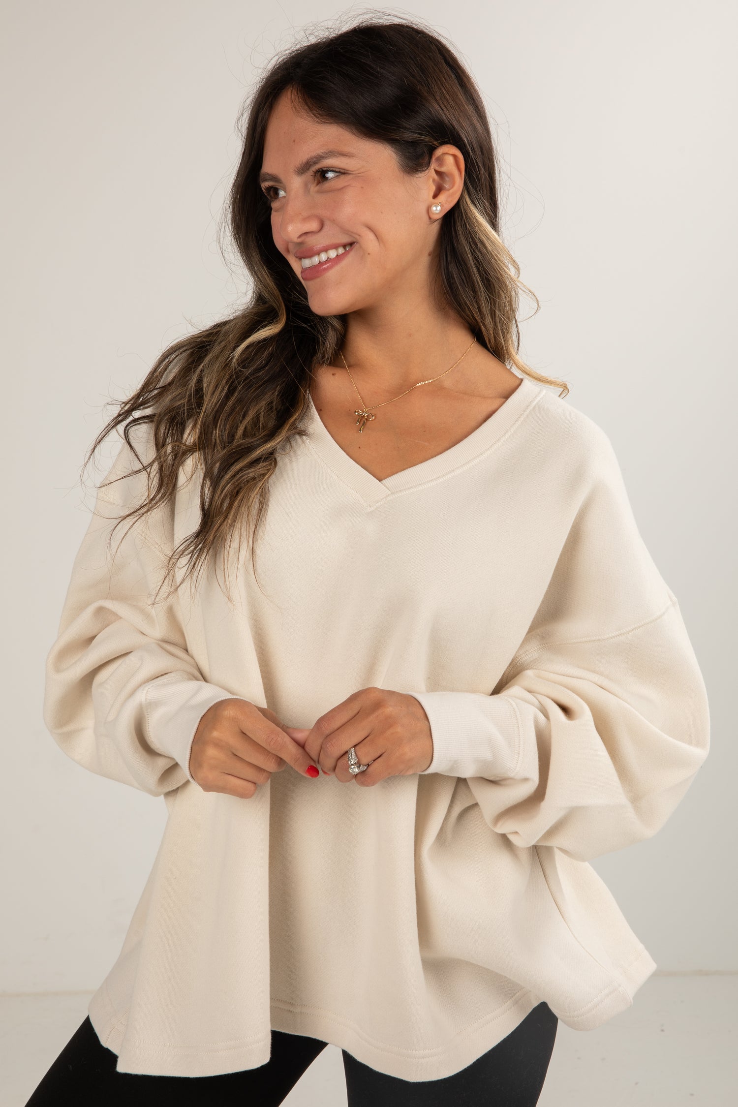 Woman wearing a beige sweater against a plain background
