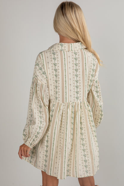 Woman wearing a patterned dress with long sleeves on a plain background