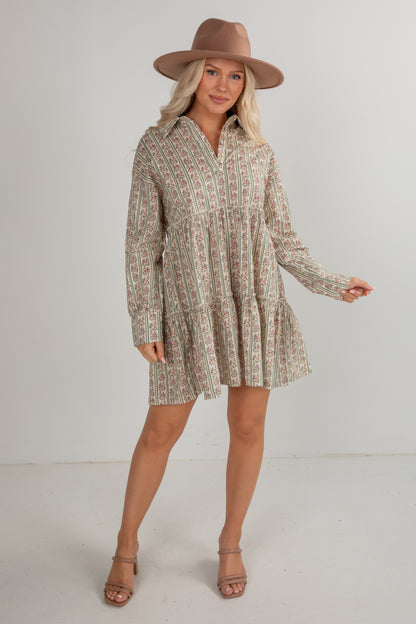 Woman wearing a patterned dress and brown hat on a white background