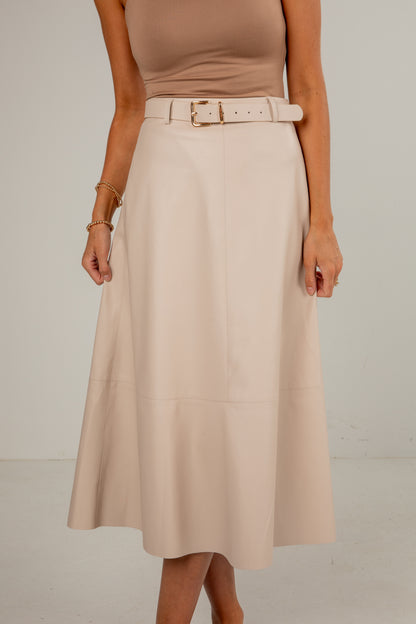 Person wearing a beige skirt with a belt on a plain background