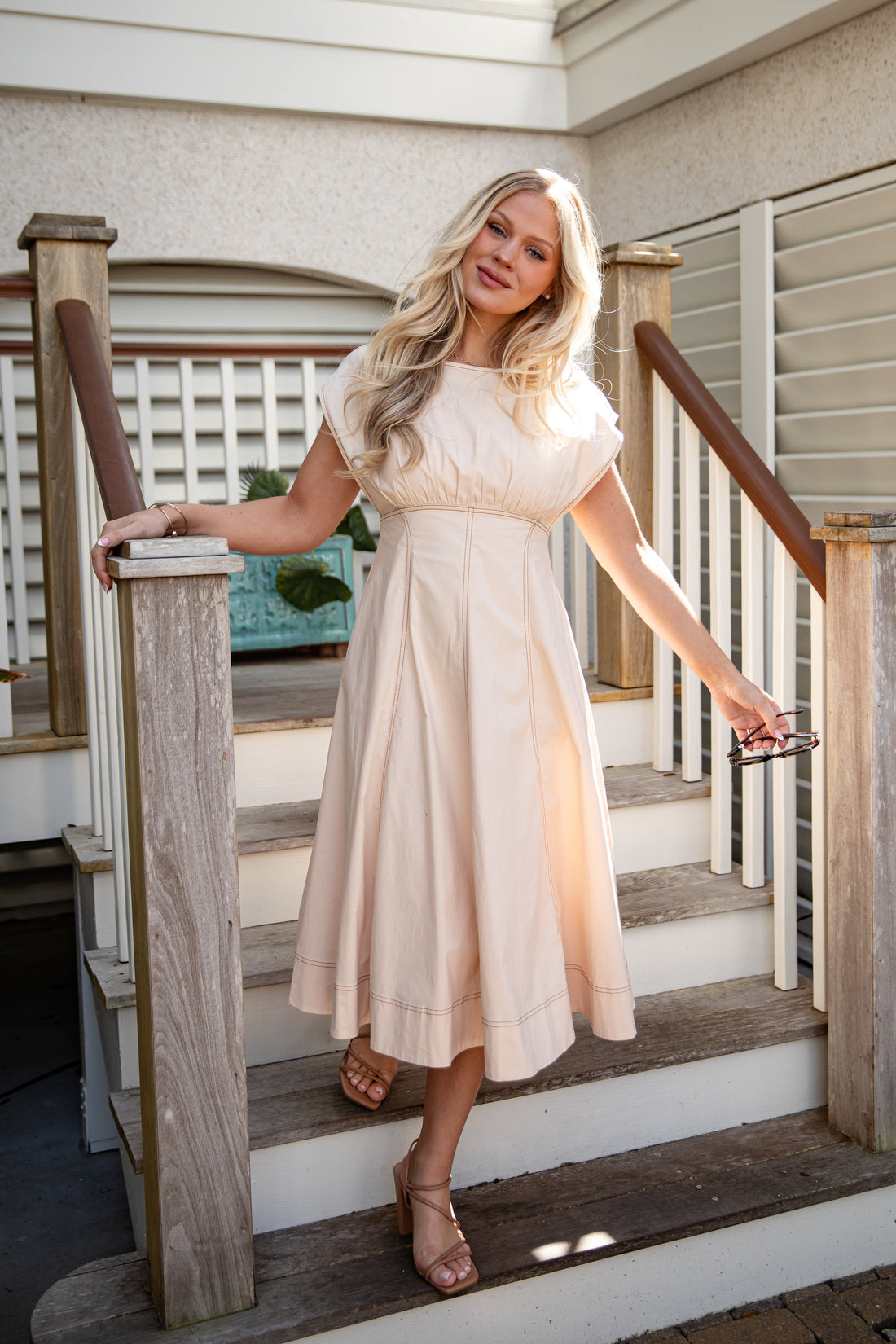 Woman in a white dress standing on a staircase