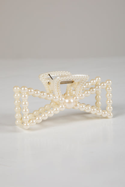 Pearl bow hair clip on a light gray background