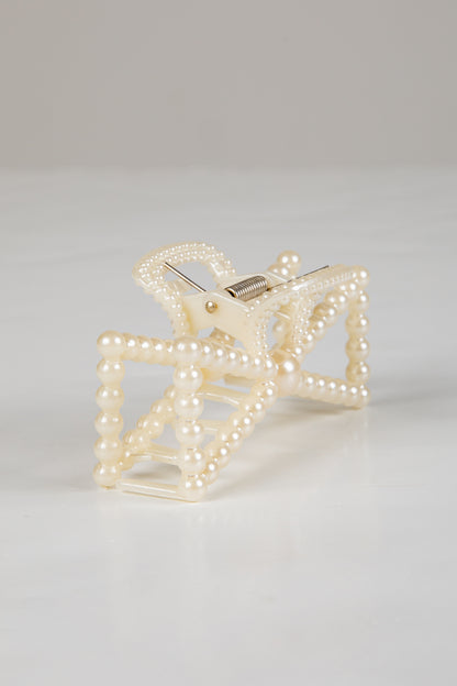 Pearl-clad clutch bag on a light gray background