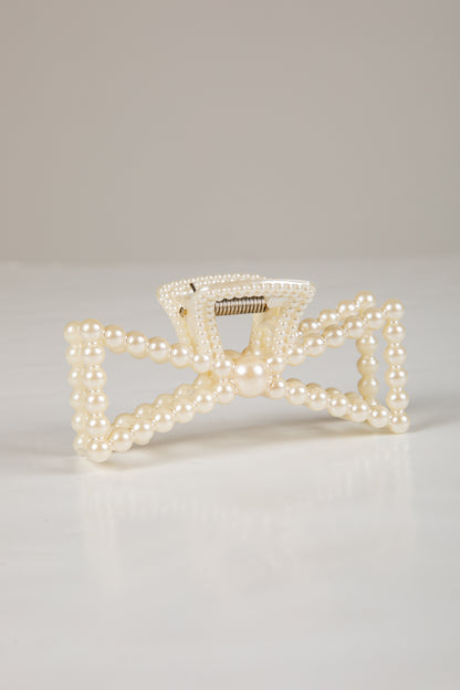 Pearl-handled clutch bag on a light gray background