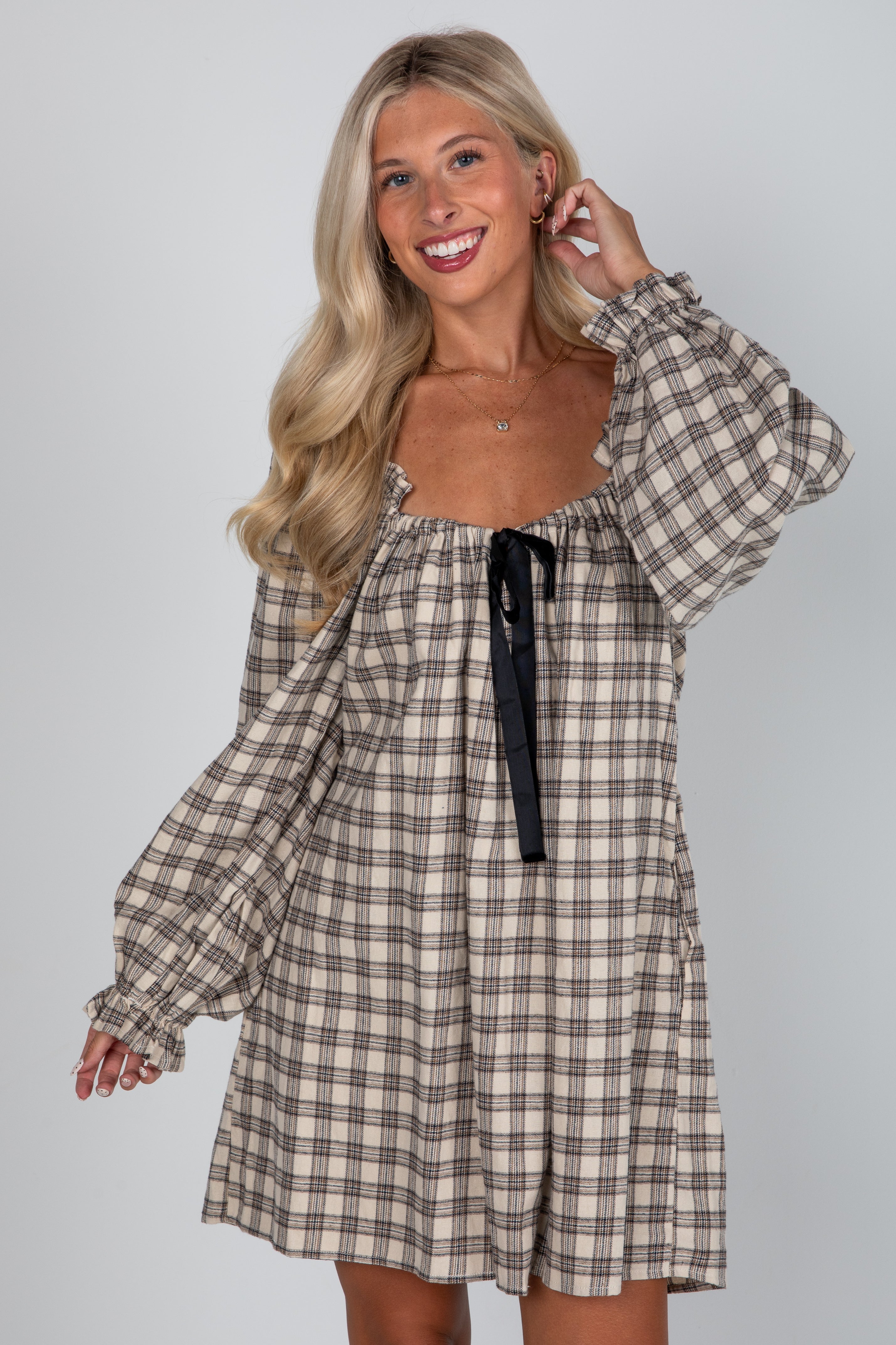 Woman wearing a plaid dress with a plain background