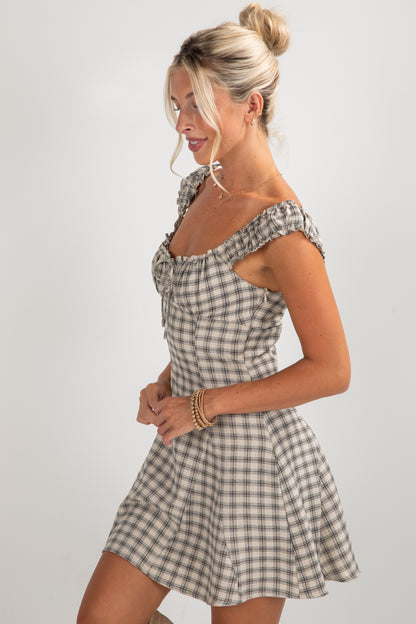 Woman wearing a checkered dress on a plain background