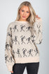 Woman wearing a beige sweater with black skeleton patterns on a plain background