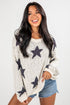 Woman wearing a sweater with star patterns on a plain background