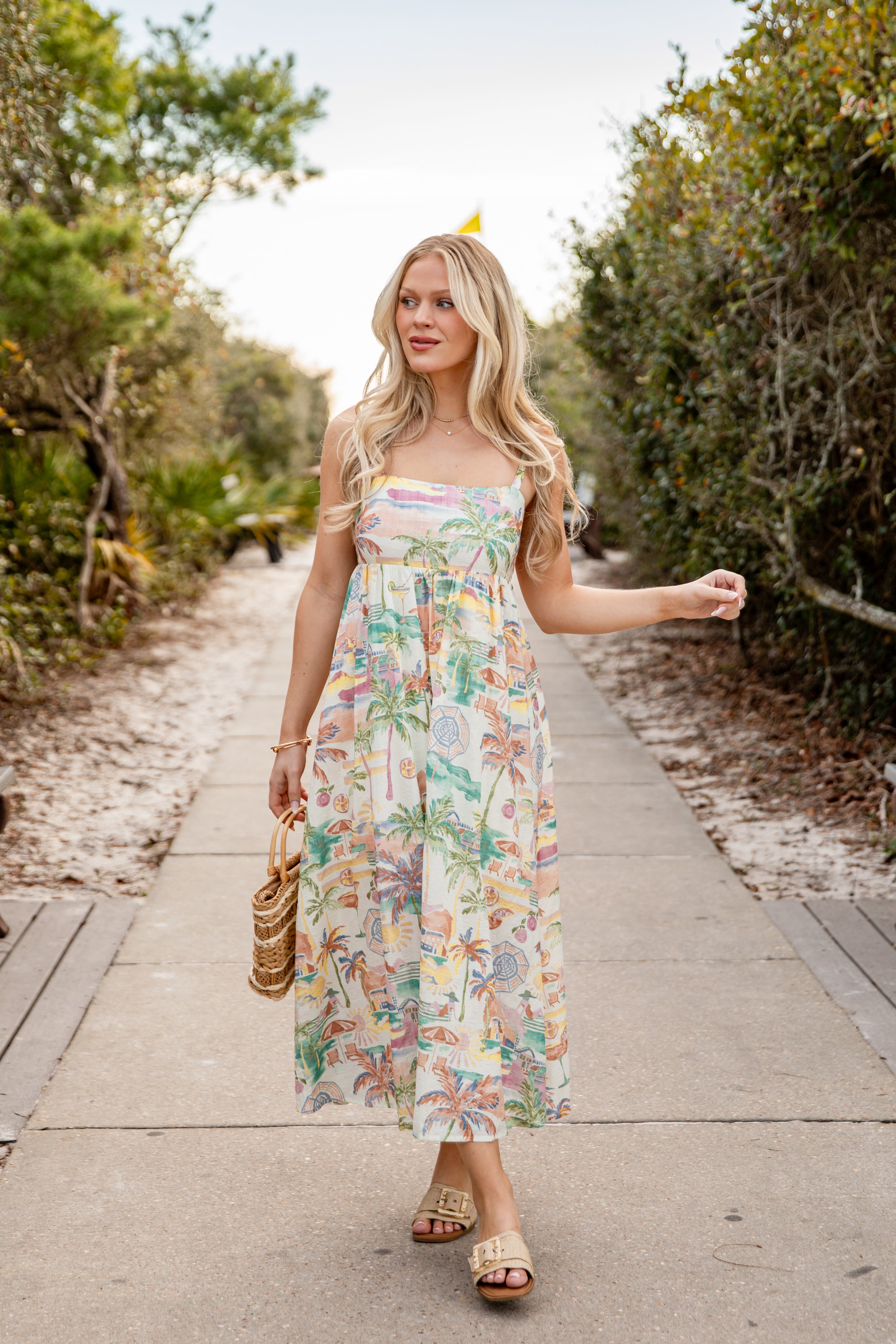 Woman in a floral dress walking on a path in a natural setting