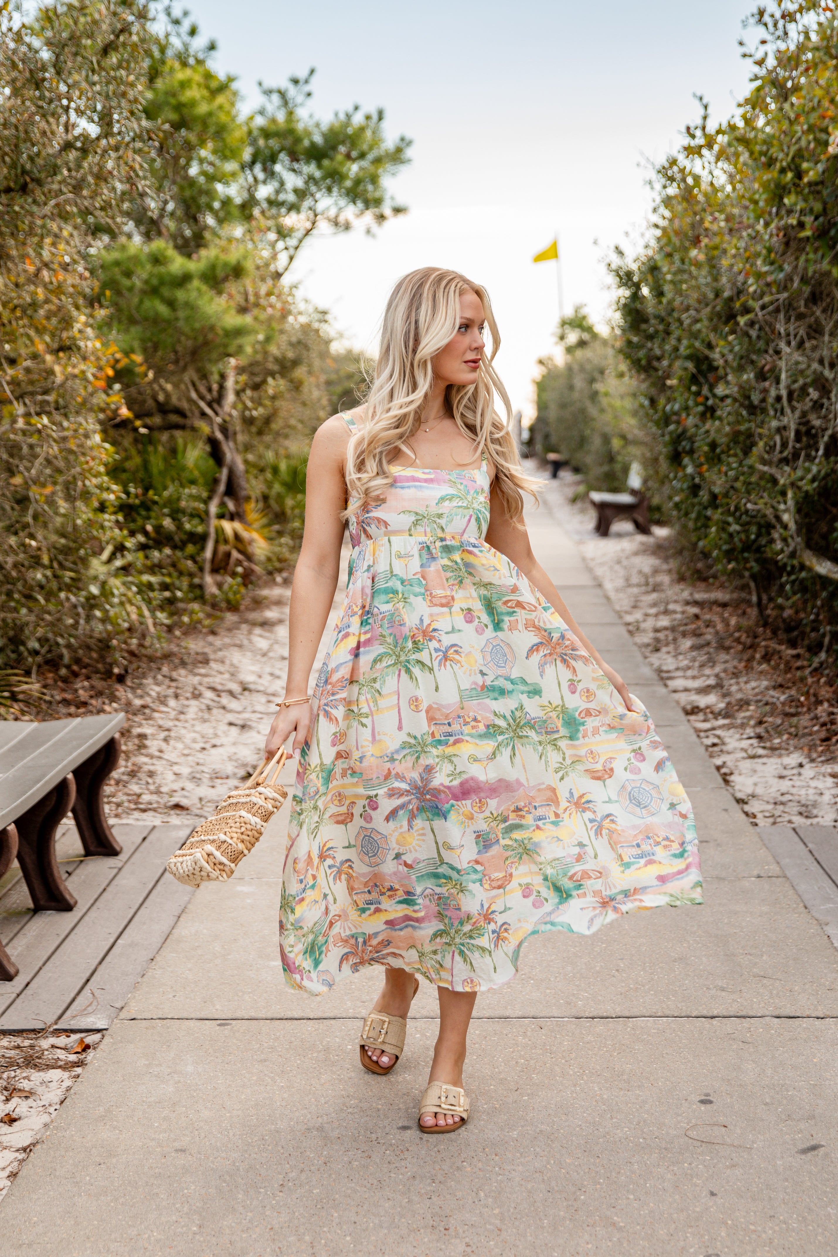 Woman in a floral dress walking on a path in a natural setting